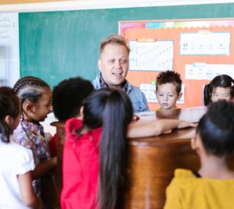 maestro che insegna musica agli alunni vicino a un pianoforte