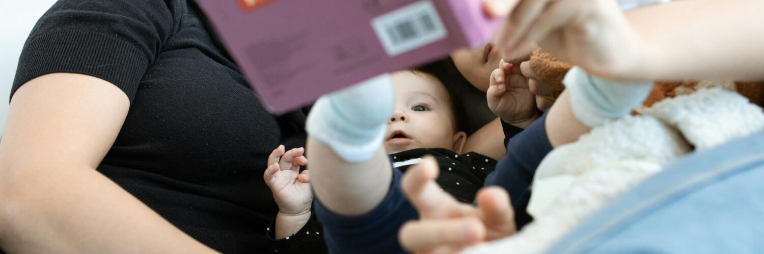 neonato a cui viene letto un libro